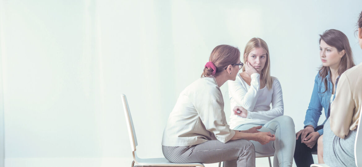 Women listening to a therapist during a session. Empty space, pl