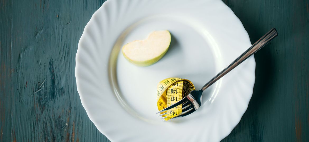 Plate with apple and measuring tape, weight loss