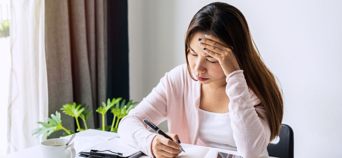 Stressed young woman calculating monthly home expenses, taxes, bank account balance and credit card bills payment, Income is not enough for expenses.