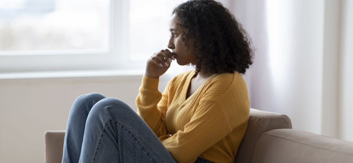 Mental health care. Depressed young black woman suffering from emotional burnout on couch at home