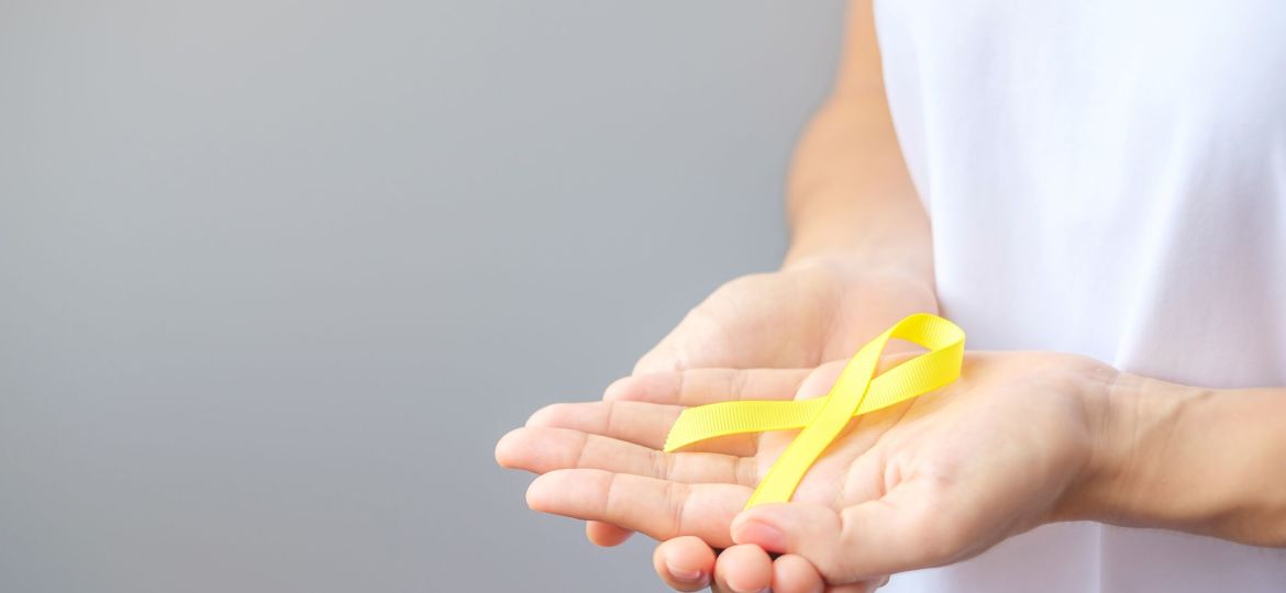 hand holding Yellow Ribbon for supporting people living and illn